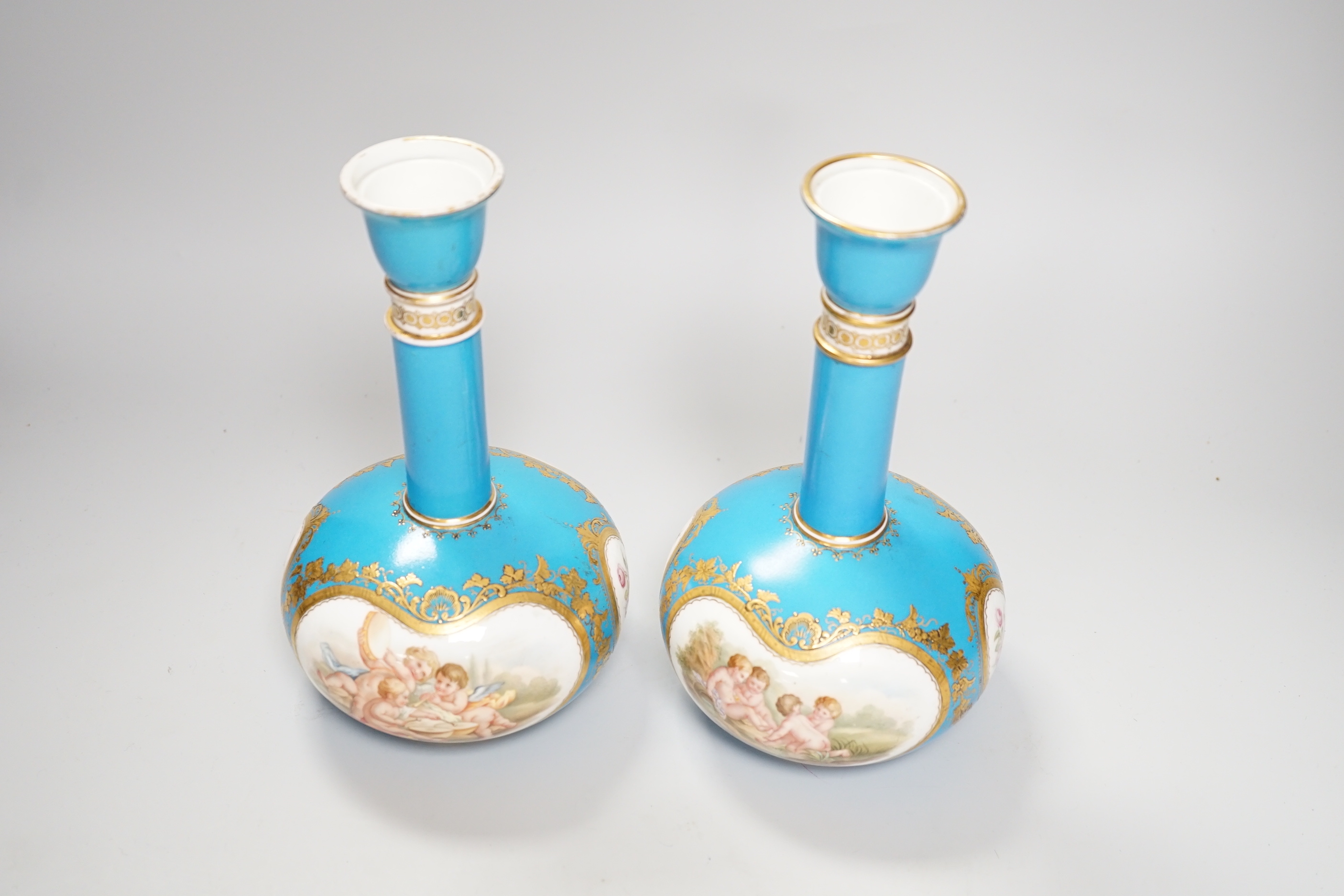 A pair of Coalport turquoise bottle vases, late 19th century, with putti and rose cartouche decoration, gilt CSN mark, 22cm high